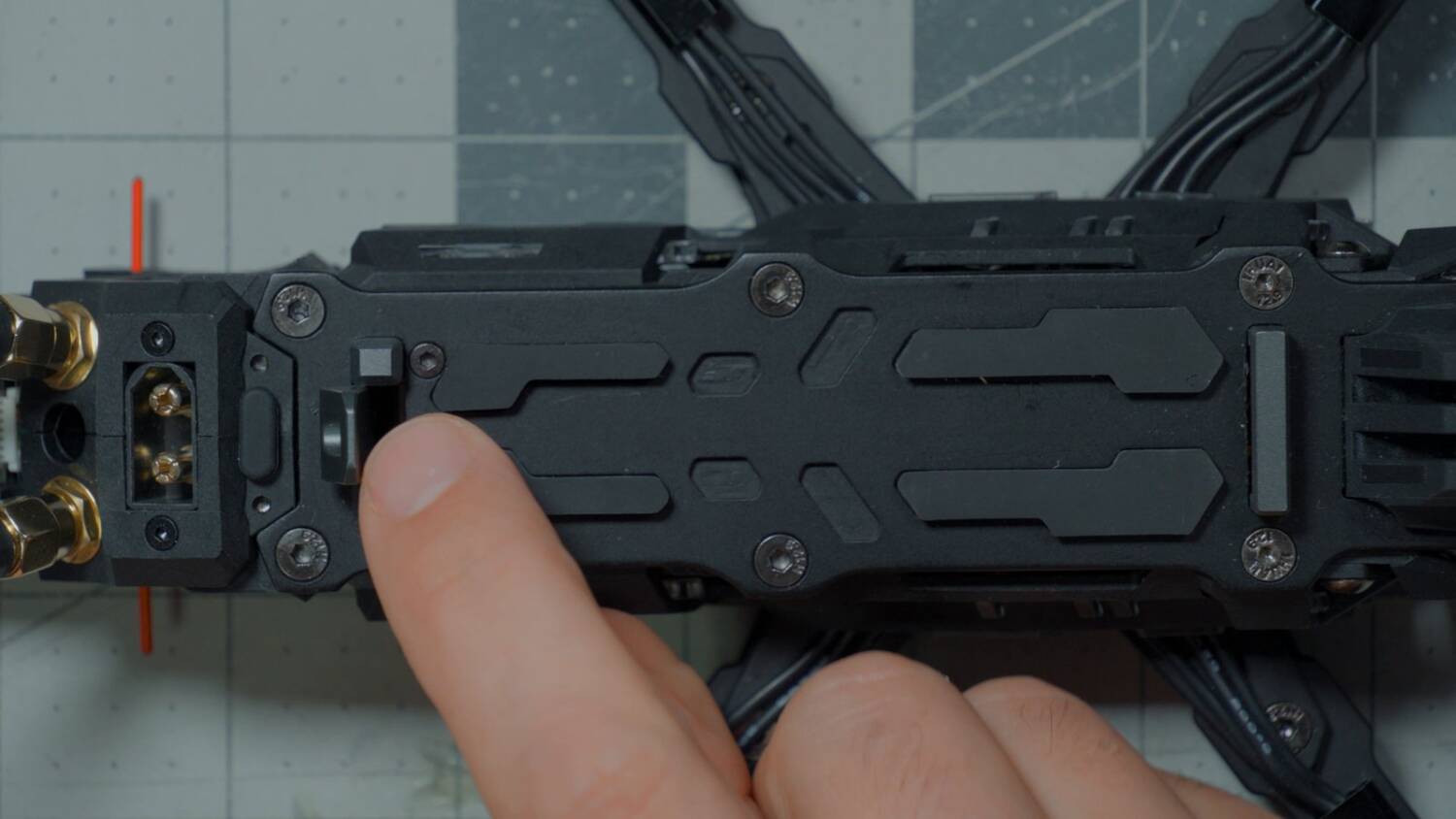The spring-loaded tab at the rear of the battery mount