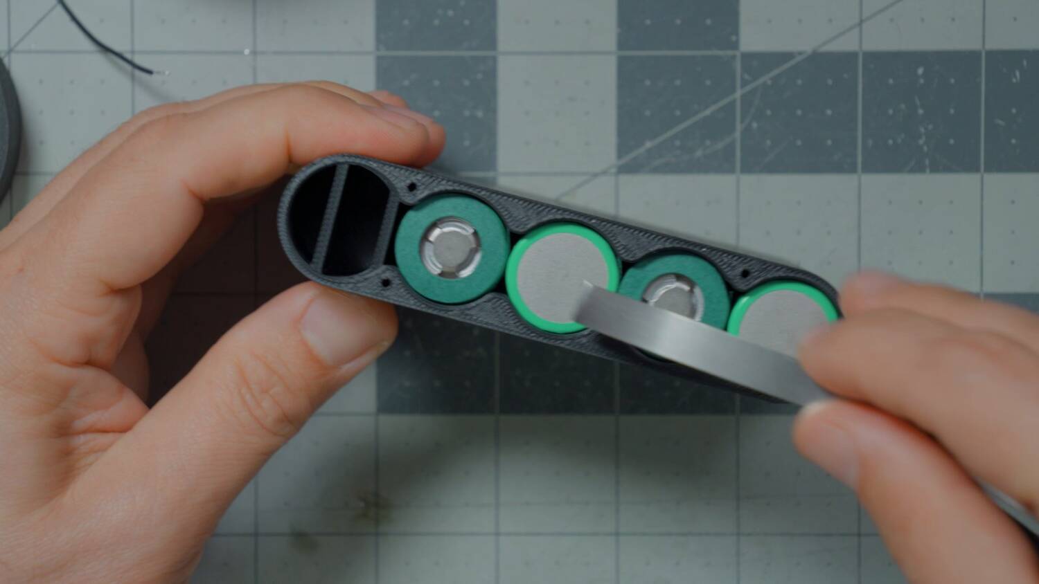 Nickel strip laid across two cells in the case to measure its length