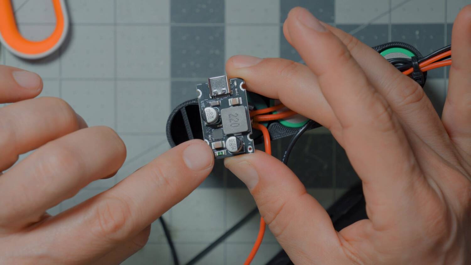 USB PD board held over the case with wires soldered to its pads