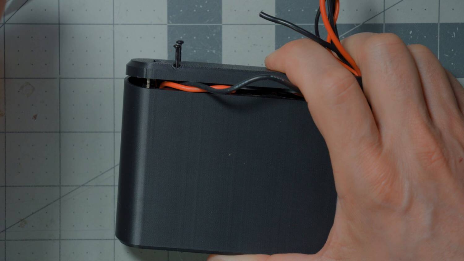 Lid being pressed onto the case with the wires coming out the top