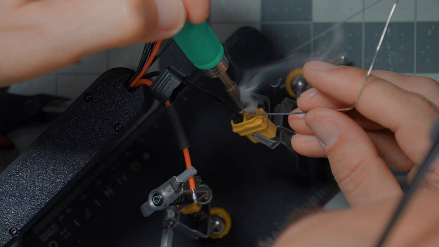 Soldering a wire onto an XT60 connector held in helping hands