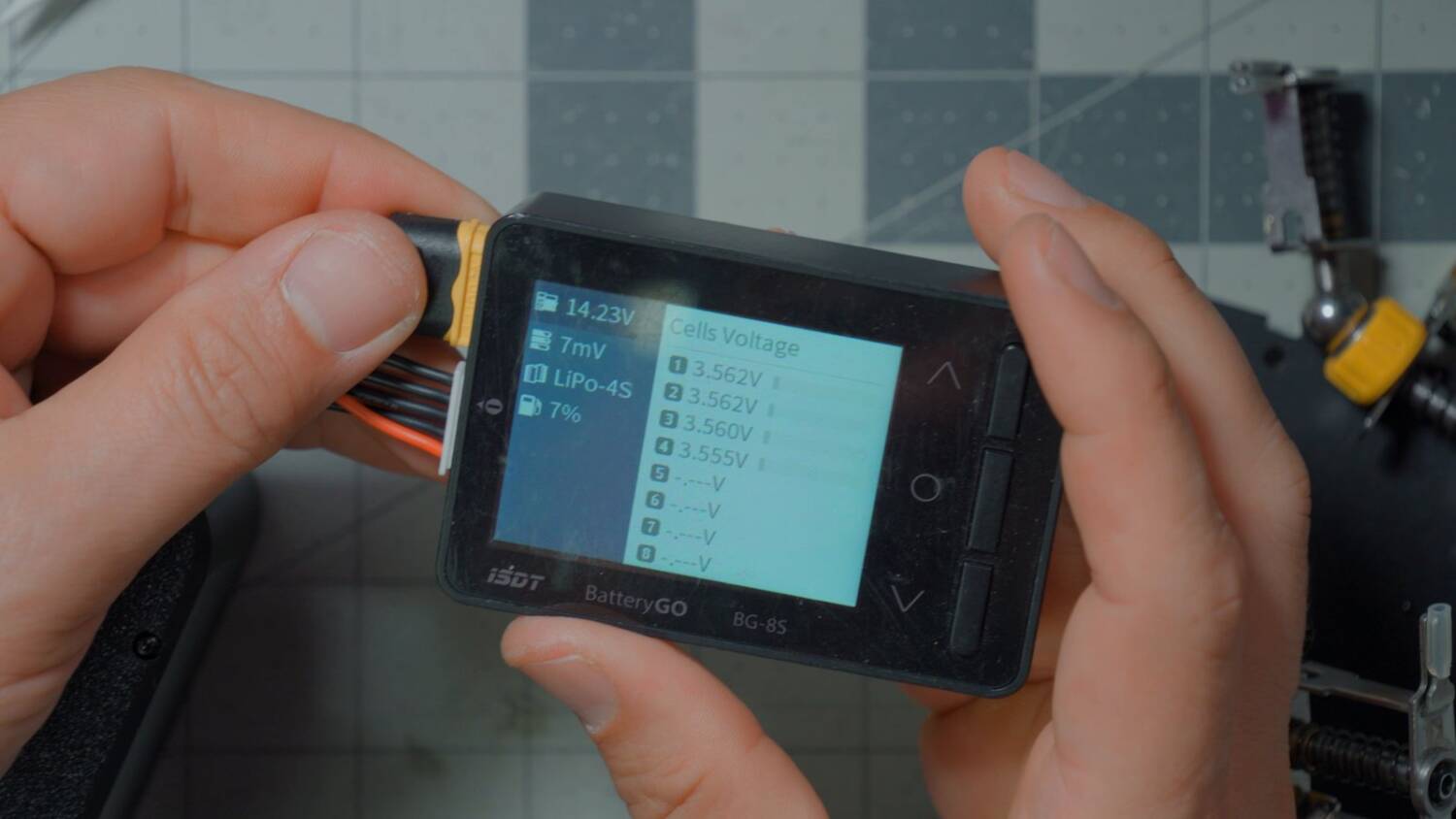 Cell checker plugged into the pack's XT60 and balance lead, reading 14.23V