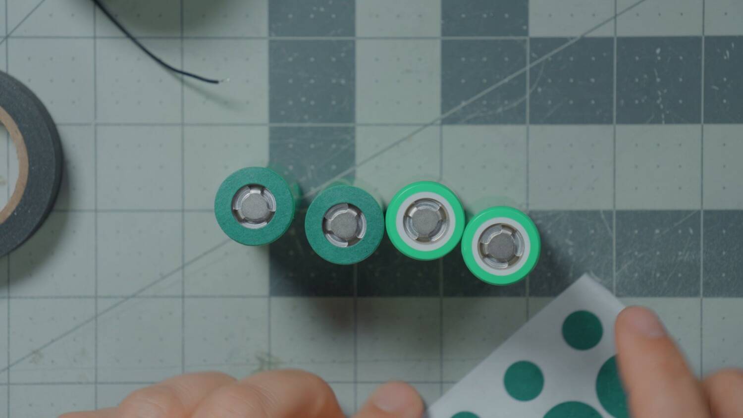 Four 21700 cells with green fish paper rings on their positive ends