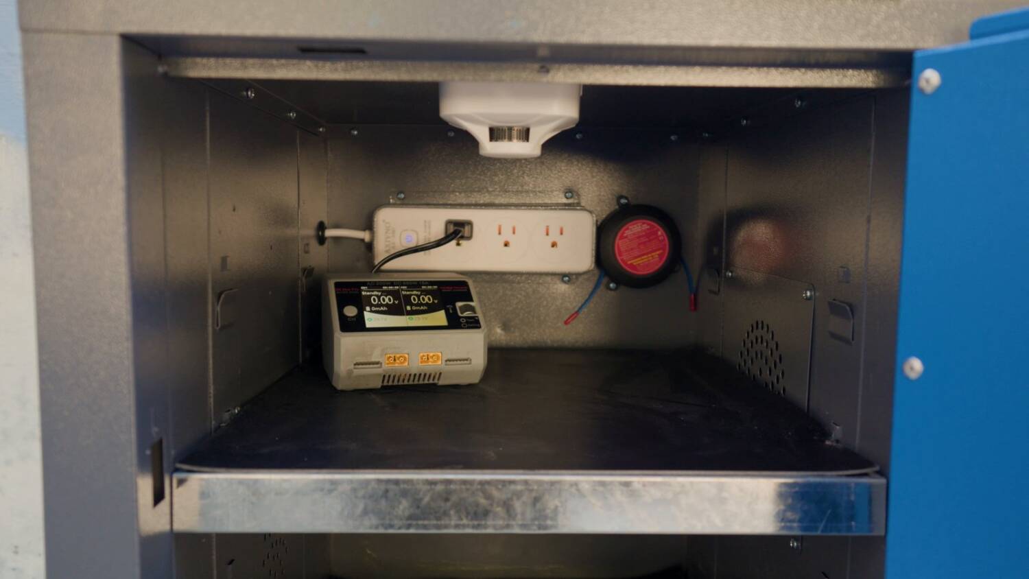 The power strip and a charger inside the cabinet